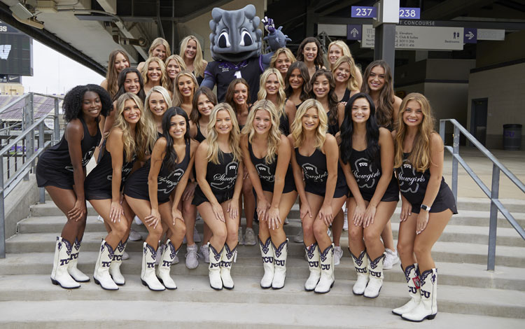 TCU Showgirls pose for a group photo with their mascot, the horned frogs, showcasing their custom Justin Boots.